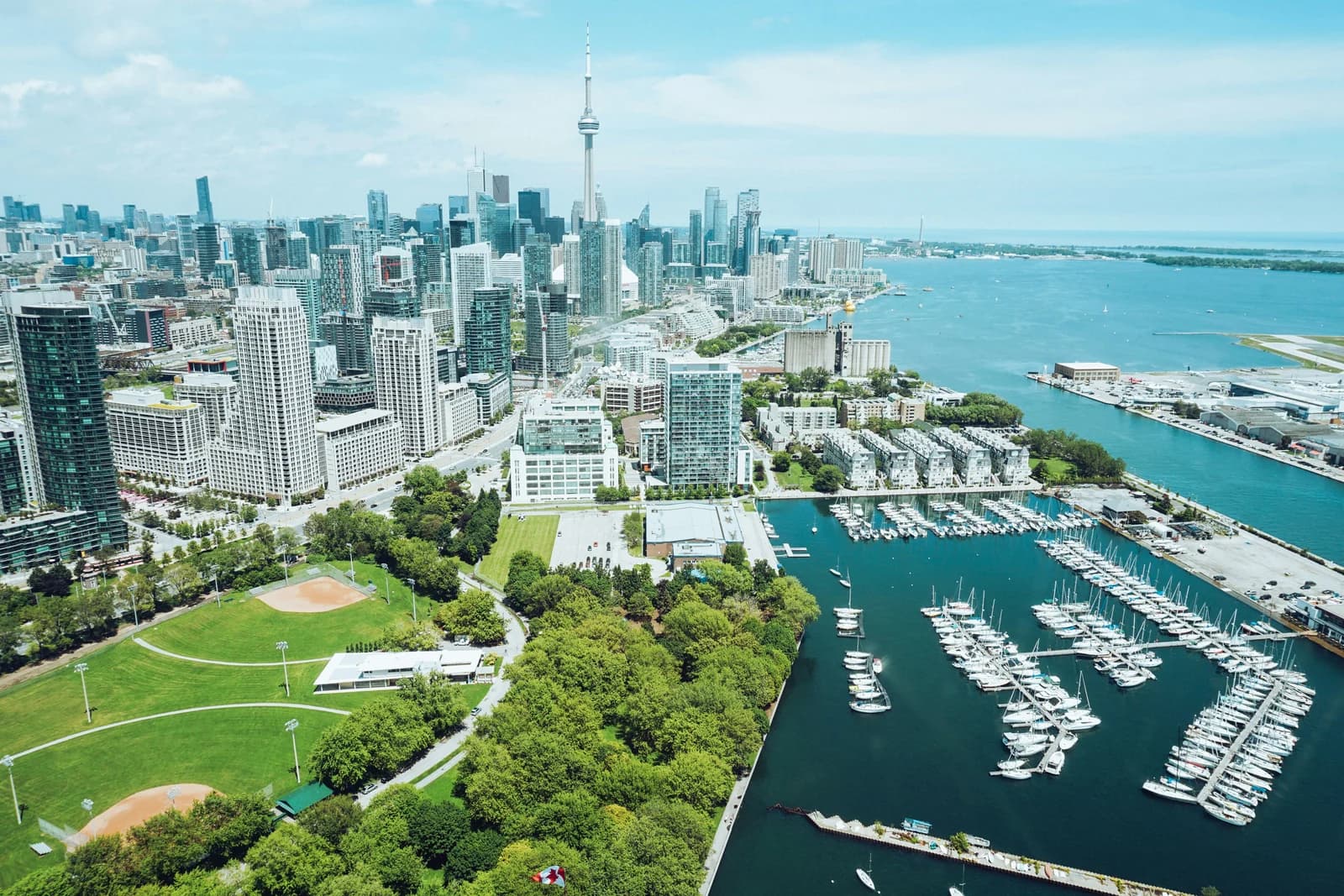 Aerial view of the Toronto city skyline, CN Tower, and a bustling waterfront marina, capturing the vibrant digital landscape served by a Web Design Agency in Toronto.