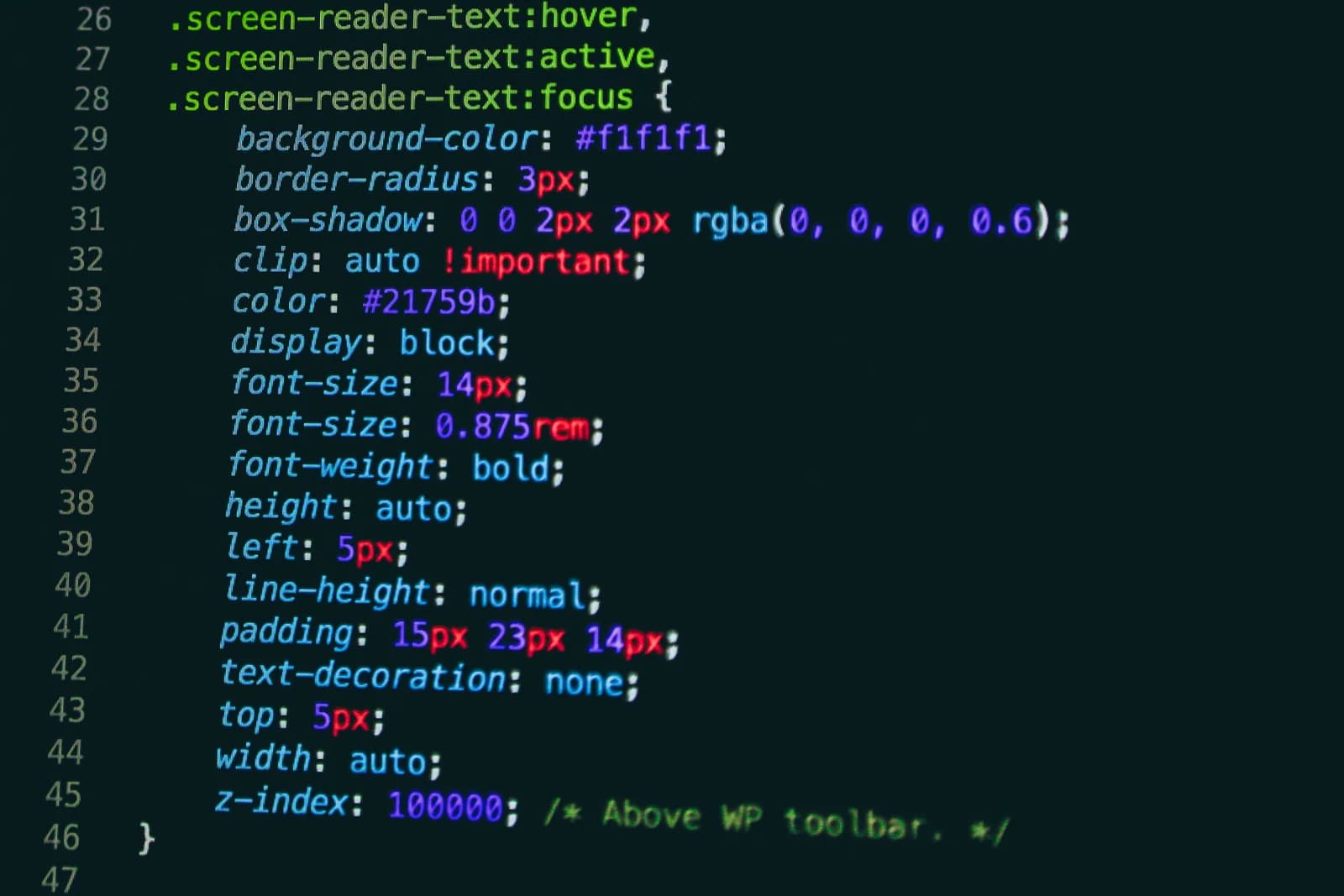 Close-up of a dark-theme code editor showing CSS rules for screen-reader-text hover, active, and focus states, with line numbers and syntax highlighting in green, pink, and blue.
