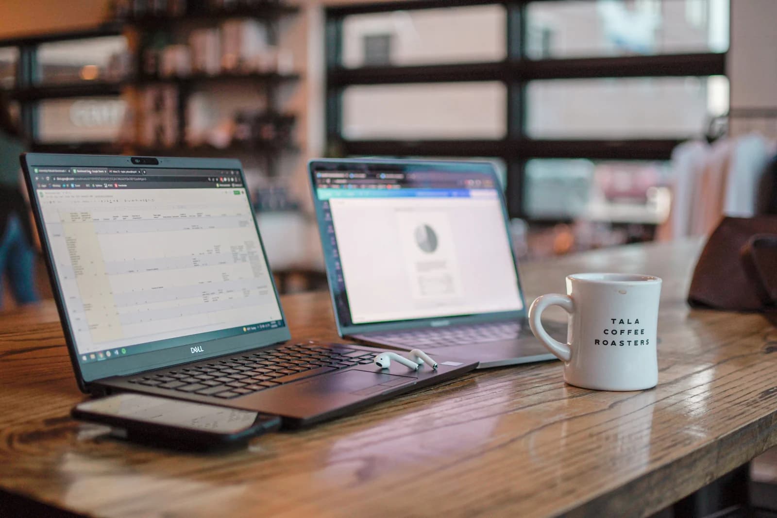 Work laptops, a smartphone, and a coffee mug on a table, illustrating a business evaluating its website design cost Toronto.