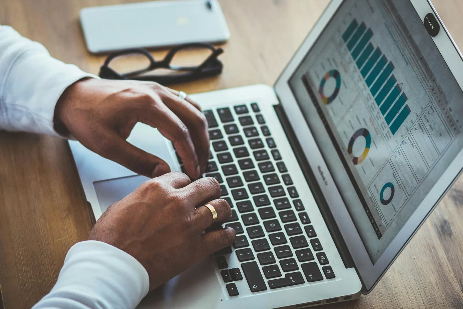 Person analyzing website traffic charts on a laptop, showing visitor activity but no leads.