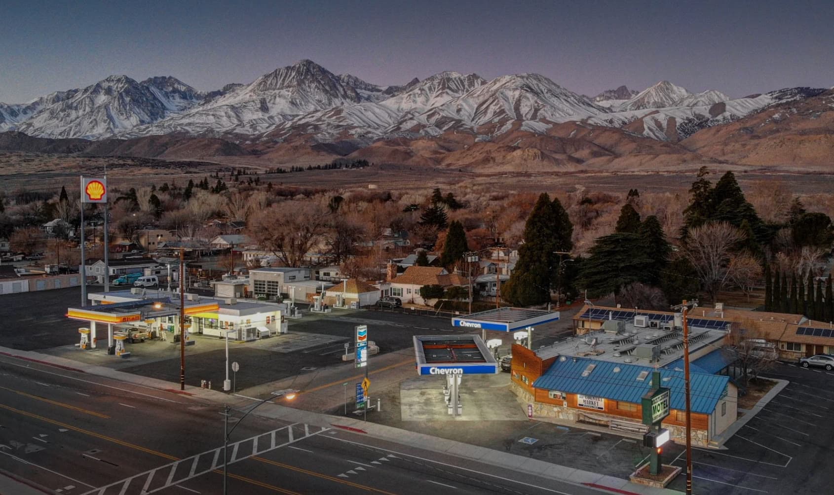 Aerial view of Big Pine, California, at dusk, with the snow-covered Eastern Sierra behind the town.