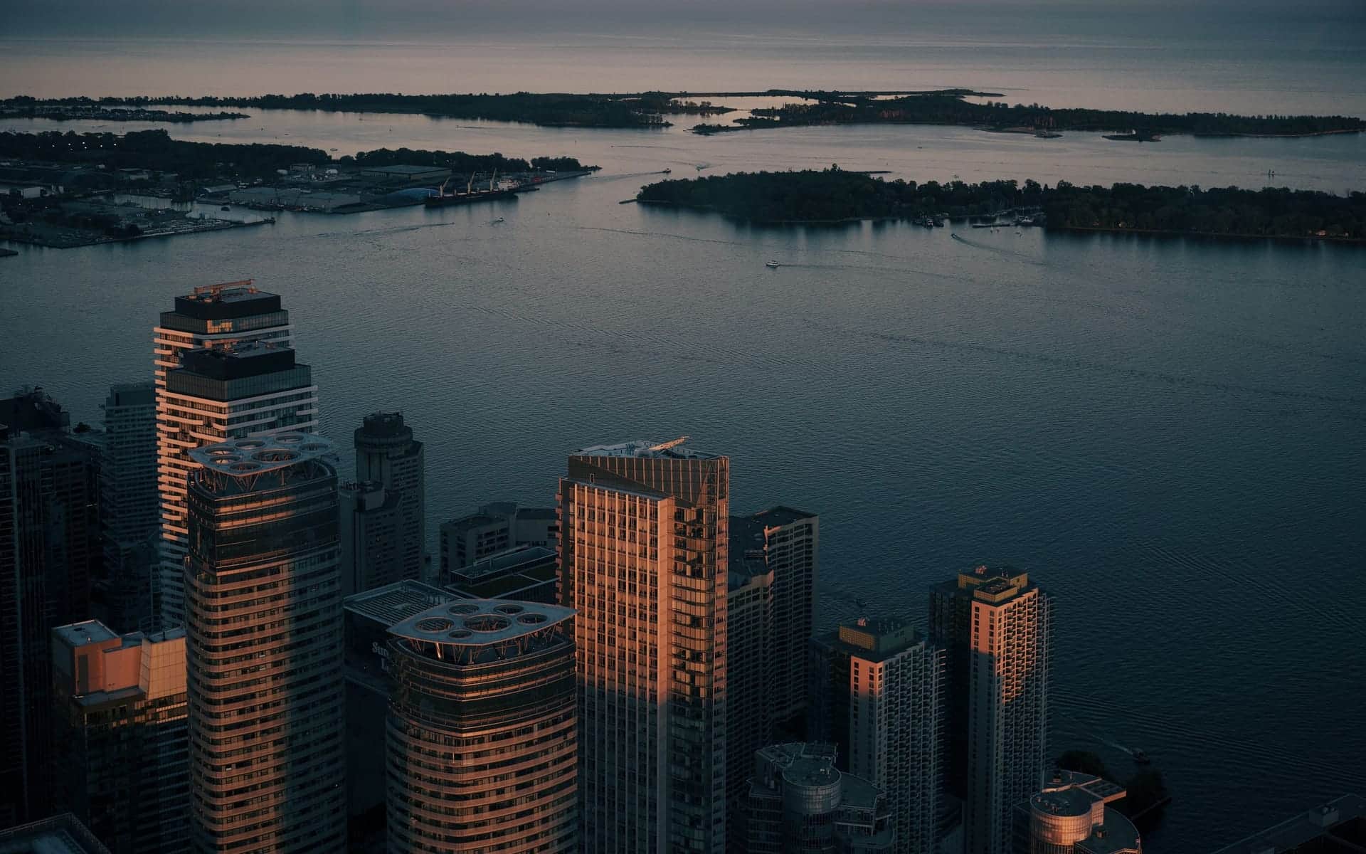 Aerial view of Toronto’s waterfront and Lake Ontario at sunset, with downtown towers in the foreground and the Toronto Islands across the water.Aerial view of Toronto’s waterfront and Lake Ontario at sunset, with downtown towers in the foreground and the Toronto Islands across the water.