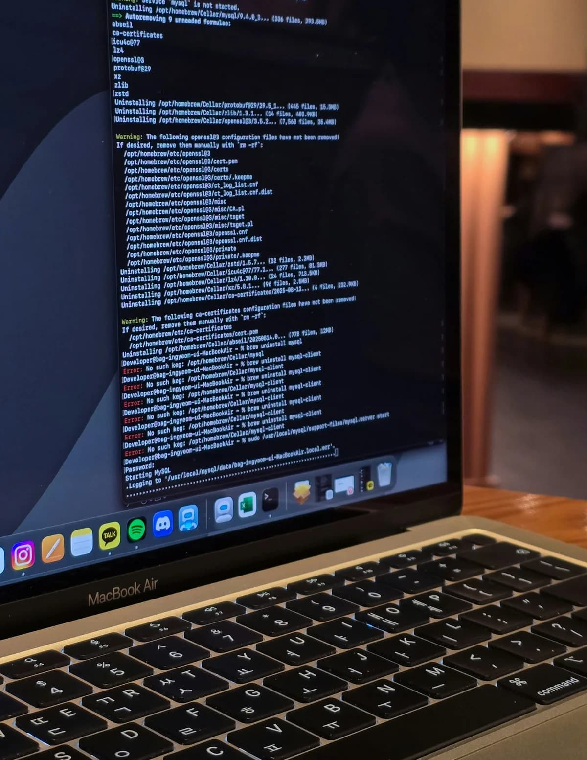 A MacBook Air showing a Terminal window full of Homebrew uninstall output and warnings about openssl@3 configuration files that were not removed, the kind of debug session that surfaces a misbehaving metadata flag.