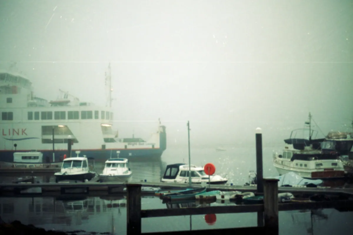 Boats at a harbour dock on a foggy day
