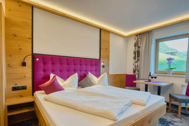 A guest room with a large bed and a window